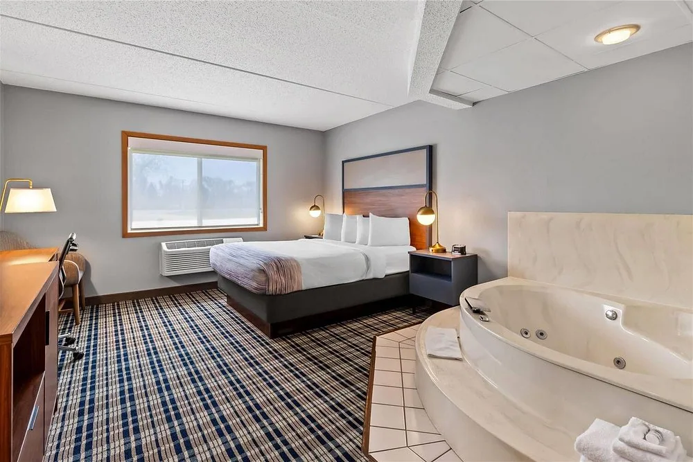 AmericInn by Wyndham Crookston — queen suite with headboard, desk and whirlpool tub