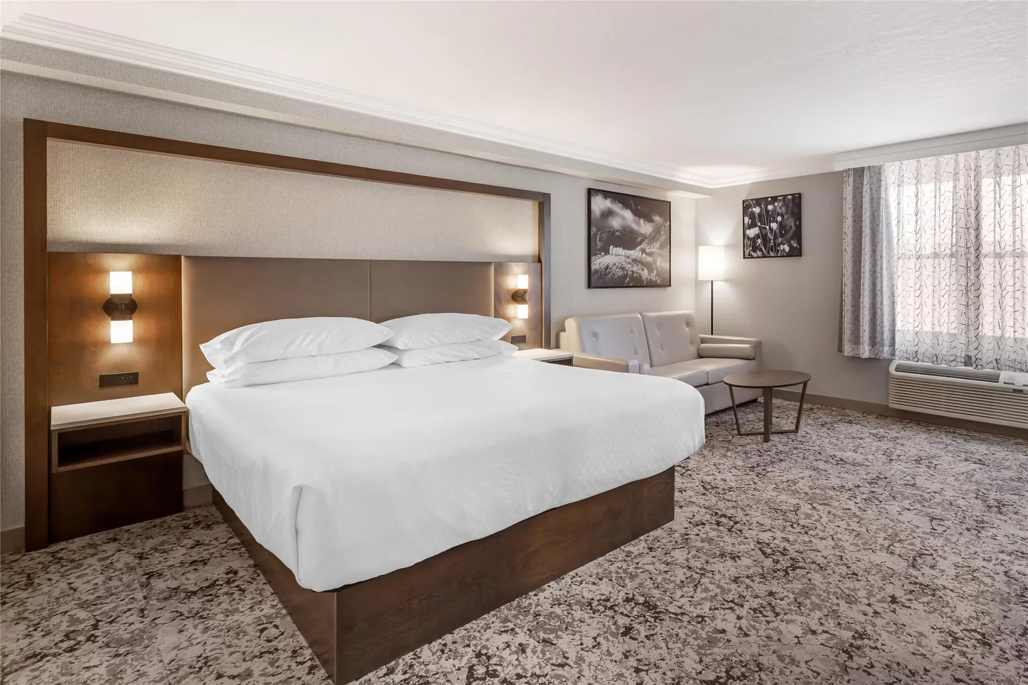 Best Western Plus The Arden Park Hotel — king guestroom with wood headboard, floating nightstands and lounge seating