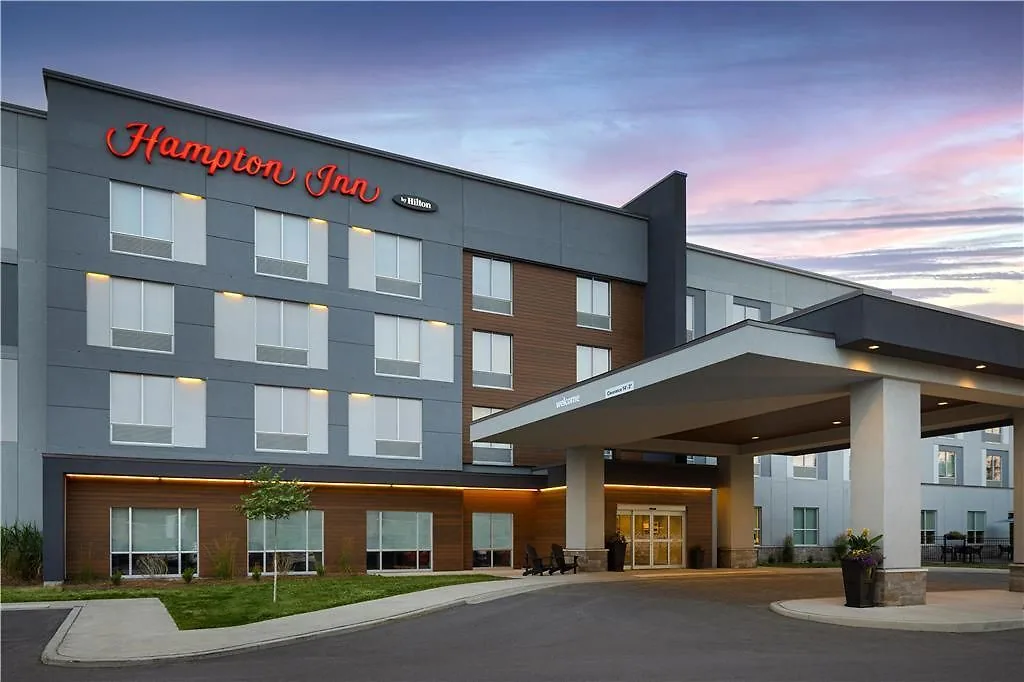 Hampton Inn & Suites Cornwall — hotel exterior at dusk with Hampton by Hilton signage
