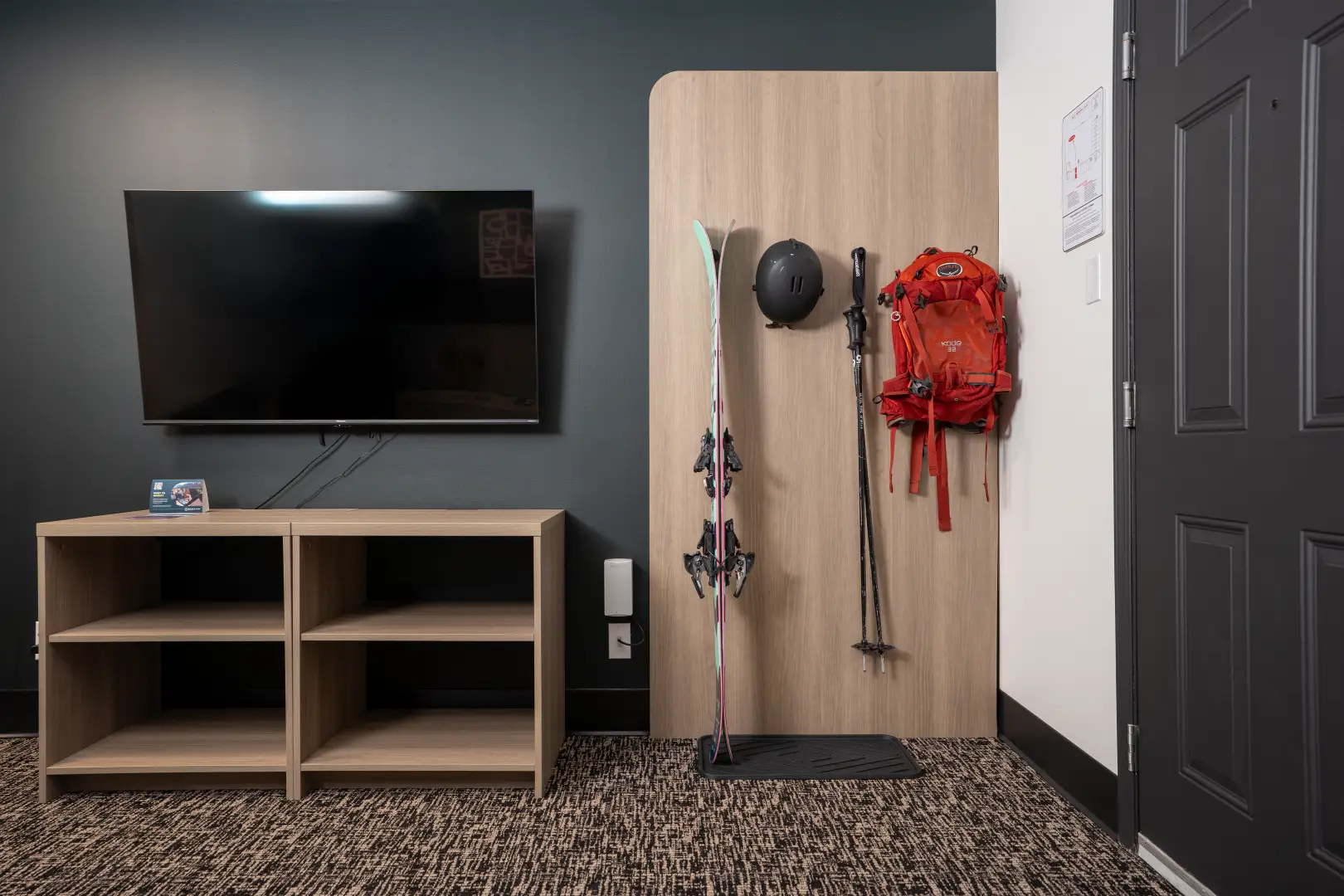 Northwinds Hotel Revelstoke — guestroom media console with open shelving and ski-storage panel