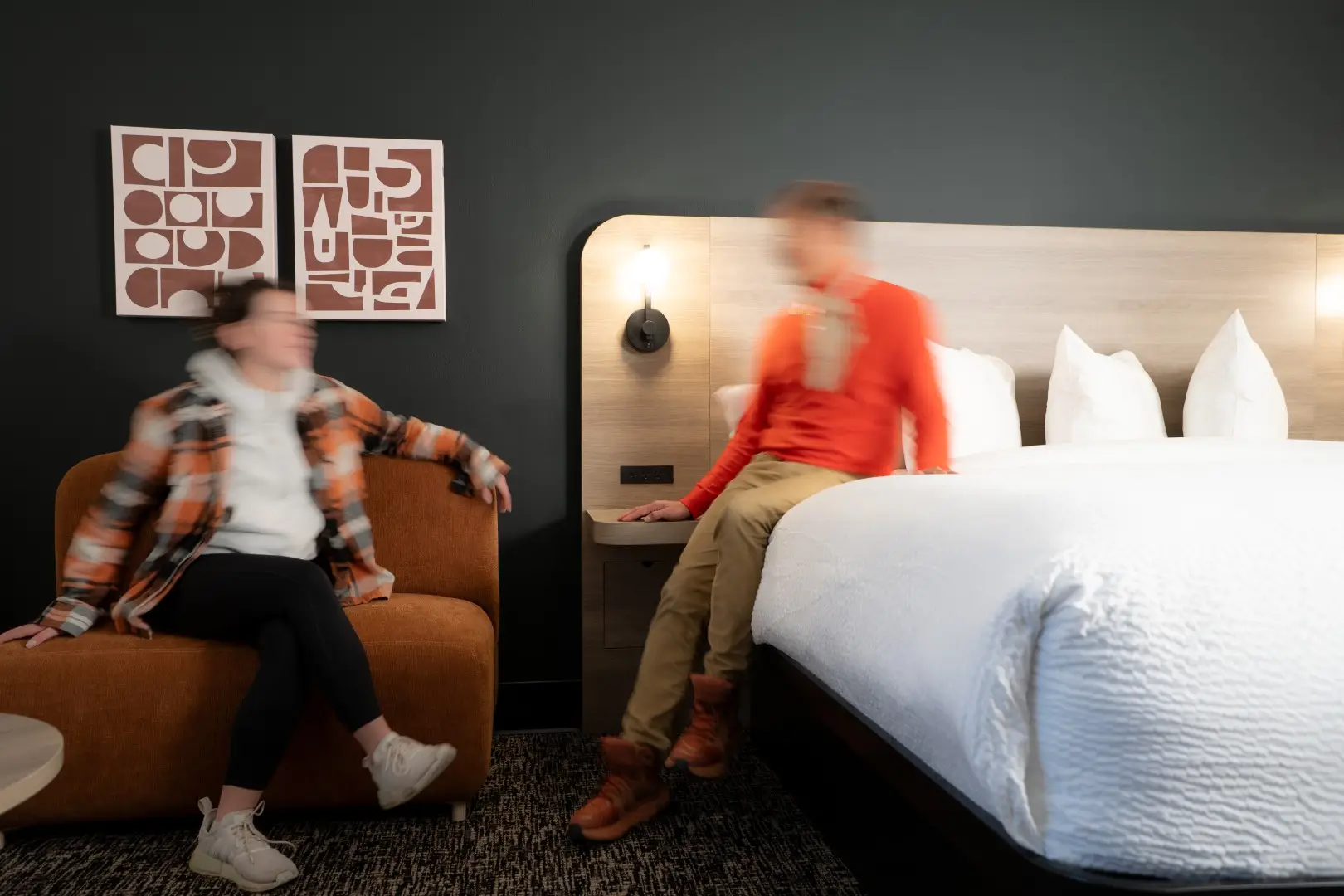 Northwinds Hotel Revelstoke — guestroom seating and bed with wood headboard and canvas art