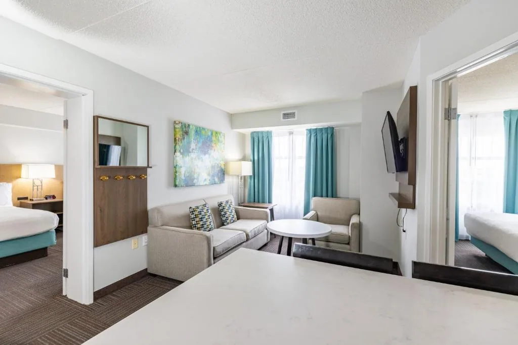 Staybridge Suites Guelph — suite living area with soft furniture and wood-framed mirror
