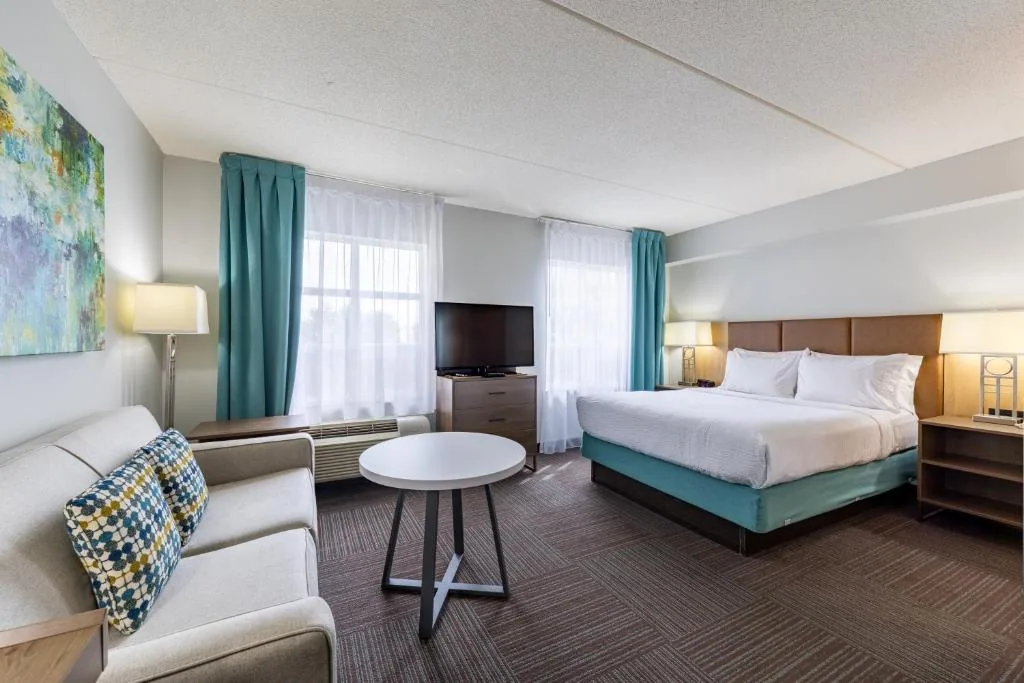 Staybridge Suites Guelph — king suite with lounge seating, headboard and case goods