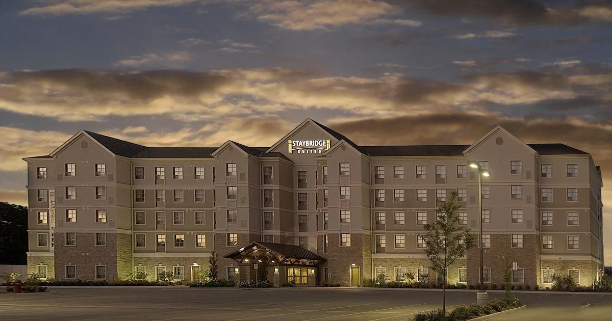 Staybridge Suites Guelph — hotel exterior at dusk with Staybridge Suites signage