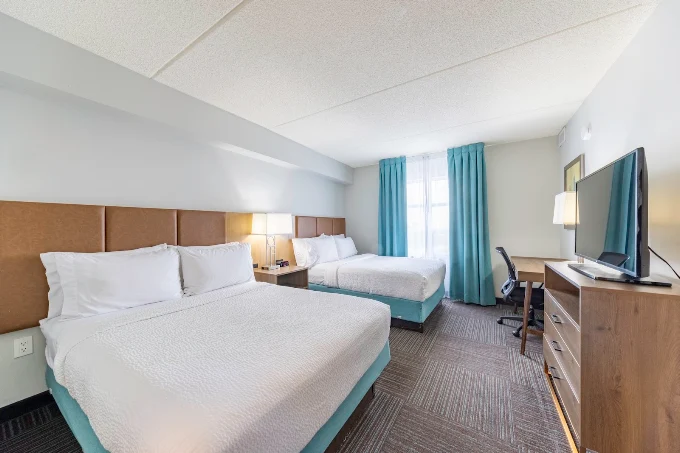 Staybridge Suites Guelph — double-queen room with headboards, nightstand and TV console
